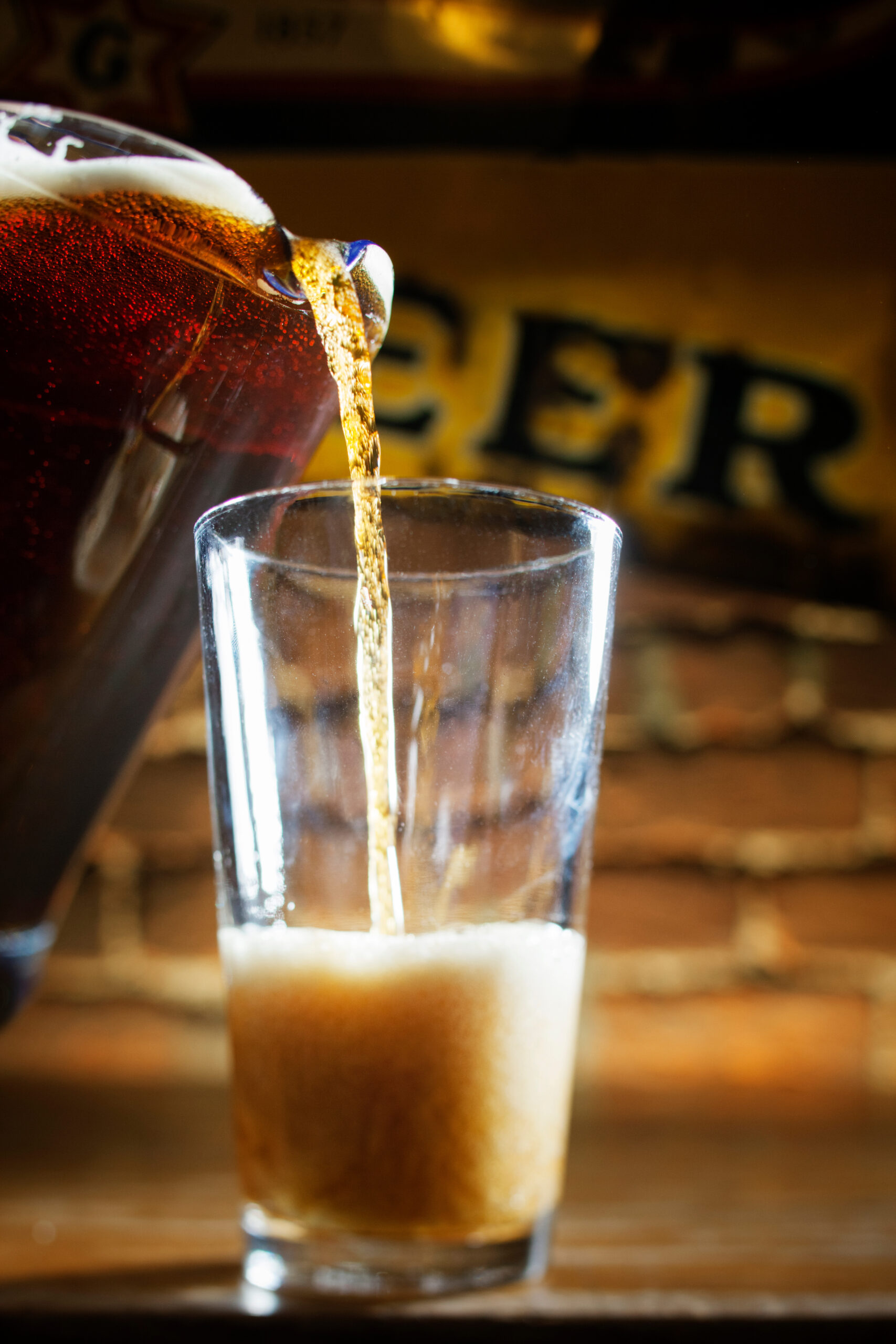 Beer being poured from pitcher in glass